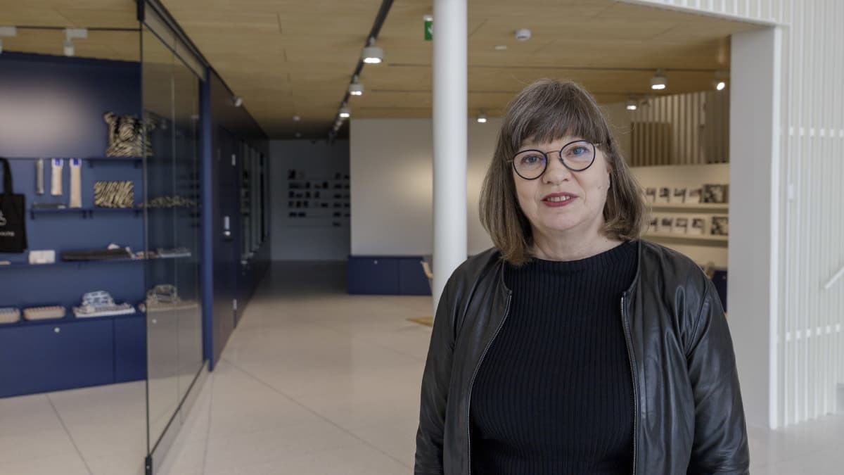 Heli-Maija Voutilainen, Jyväskylän kaupungin museotoimenjohtaja, seisoo uudessa Alvar Aalto-museossa ja katsoo kameraan.