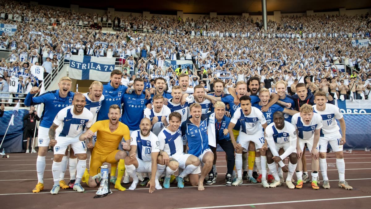 Huuhkajat joukkuekuvassa fanikatsomo Pohjoiskaarteen edessä.