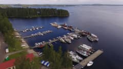 Ilmakuva kesäisestä Heinäveden kirkonkylän satamasta, jossa useita veneitä ja laivoja laiturissa.