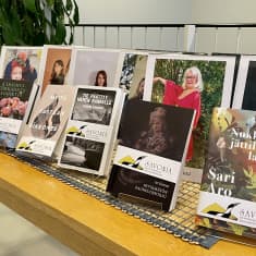 Kirjoja ja valokuvia aseteltuna pöydälle.