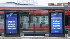 Onnitteluviesti aituri Reetta Hurskeelle bussipysäkin mainostaulussa Tampereella.