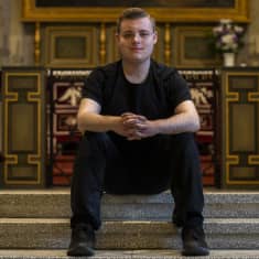 Kuusankoskelainen Jani Karjalainen istumassa Kuusankosken kirkon alttarilla.