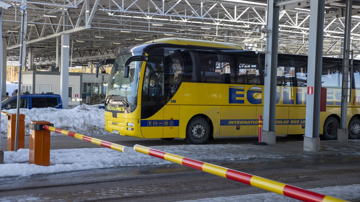 venäläinen keltainen bussi raja-aseman puomin takana talvella