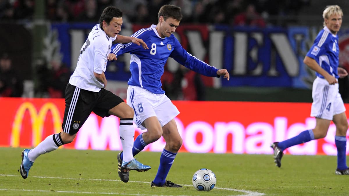 Mesut Özil ja Tim Sparv kamppailevat pallosta Suomen ja Saksan välisessä MM-karsintaottelussa 2009.