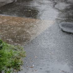 Regnoväder i Helsingfors. Gångväg är täckt av vatten. 