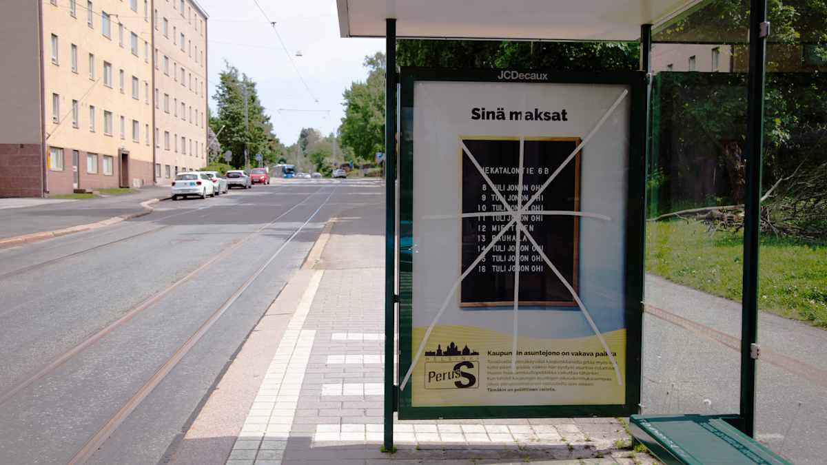 Perussuomalaisten vaalimainoksen päälle on vedetty teipit Helsingin Viipurinkadulla.