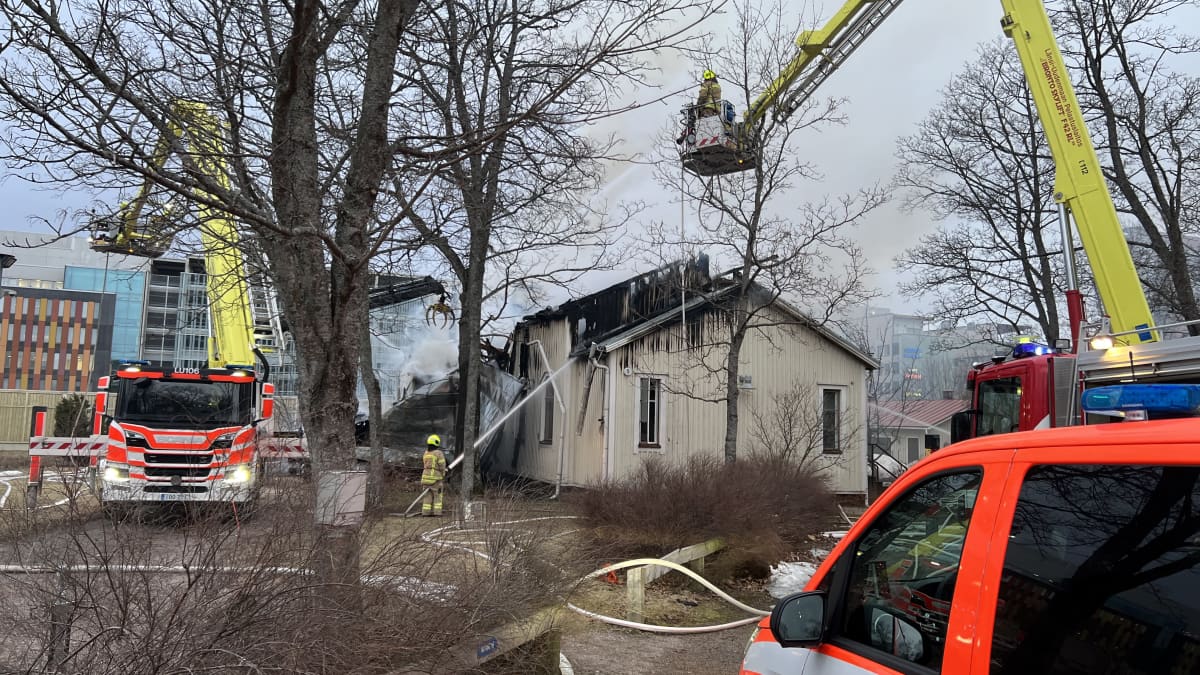 Espoon Perkkaan seurakuntatalo on tulessa. Paloautot ympäröivät jo pahasti palanutta seurakuntataloa. 