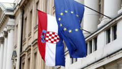 Kroatian ja Euroopan Unionin liput liehuvat vanhan rakennuksen parvekkeelta.