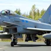 Britannian ilmavoimien Eurofighter Typhoon -hävittäjä rullaa Rovaniemen lentokentällä taustallaan kesäistä koivumetsää.