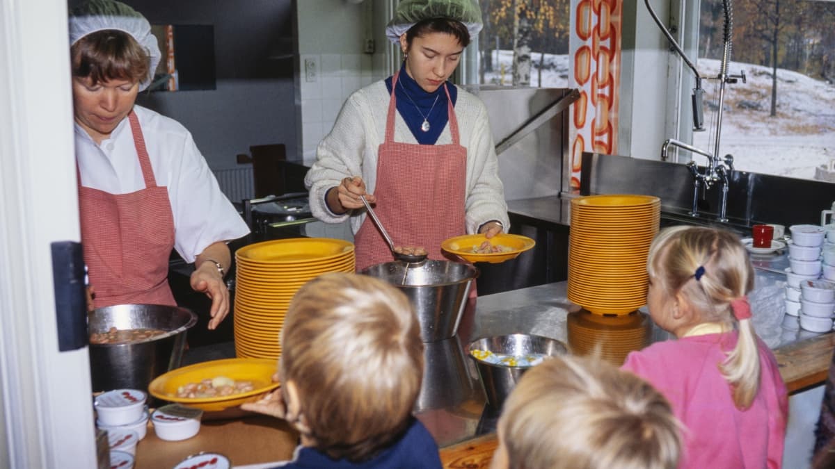 Koululaiset jonottavat ateriaa tiskillä, jolla keittäjät jakavat ruokaa keittiöstä Hillerikujan koulussa, Helsingissä lokakuussa 1992.