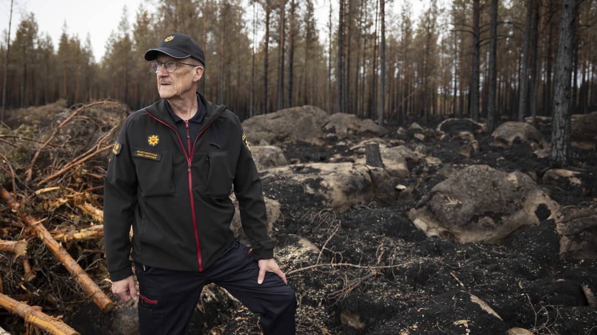 Pelastusjohtaja Jarmo Haapanen taustallaan palanutta metsää. 