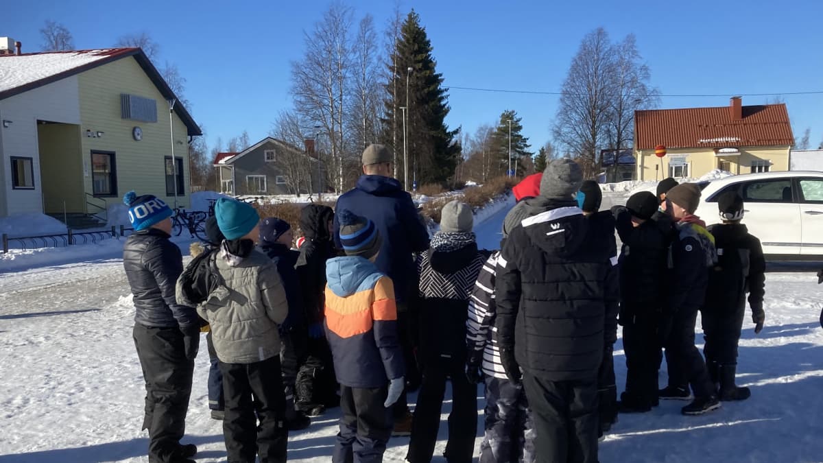 Joukko lapsia koulun pihalla Merijärvellä.