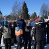 Joukko lapsia koulun pihalla Merijärvellä.
