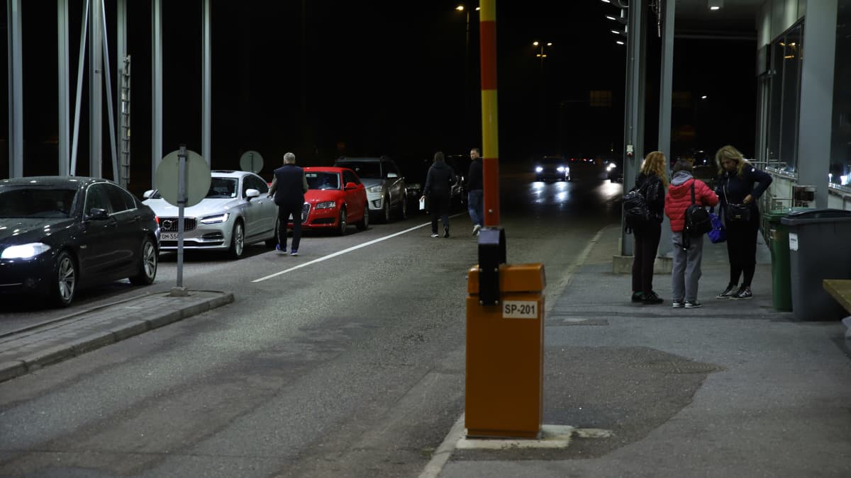Ihmisiä ja autoja rajanylityspaikalla Vaalimalla yöllä.