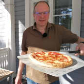 Kotikokki Juha Sivonen esittelee juuri uunista otettua pizzaa.