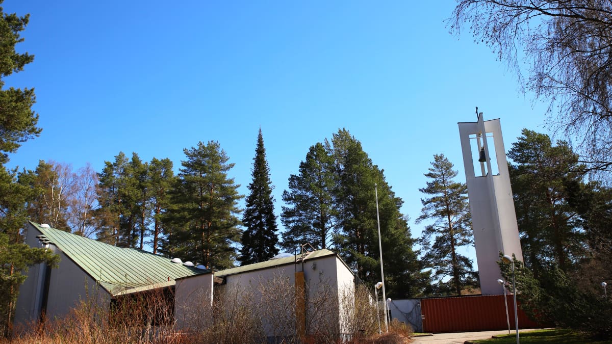Kuvassa näkyy valkoseinäinen ja vihreäkattoinen Lohikosken seurakuntakeskus sekä avoin ja pelkistetty kellotorni.