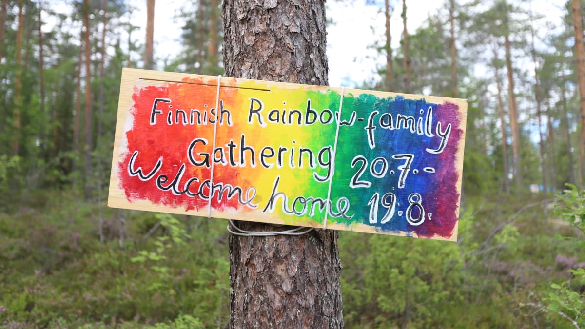 Puussa roikkuu kyltti, joka toivottaa Rainbow-perheen tervetulleeksi leirille