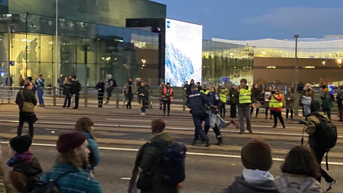 poliisi kantaa mielenosoittajaa