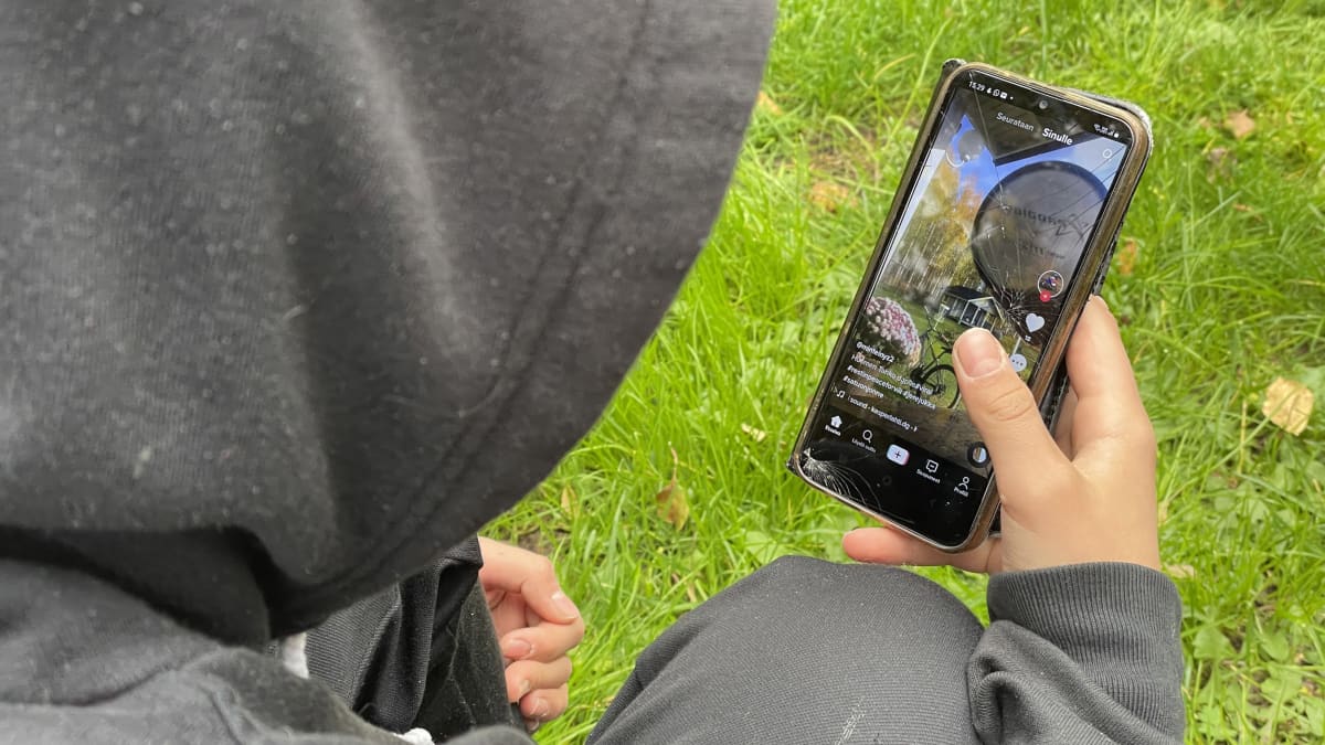 Nuori selaa kännykästään TikTokin videoita