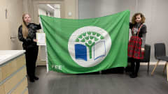 Kaksi tyttöä pitää FEE vihreää lippua