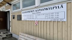 Rauhaniemen kansankylpylän kyltti pukuhuoneen ulkoseinällä