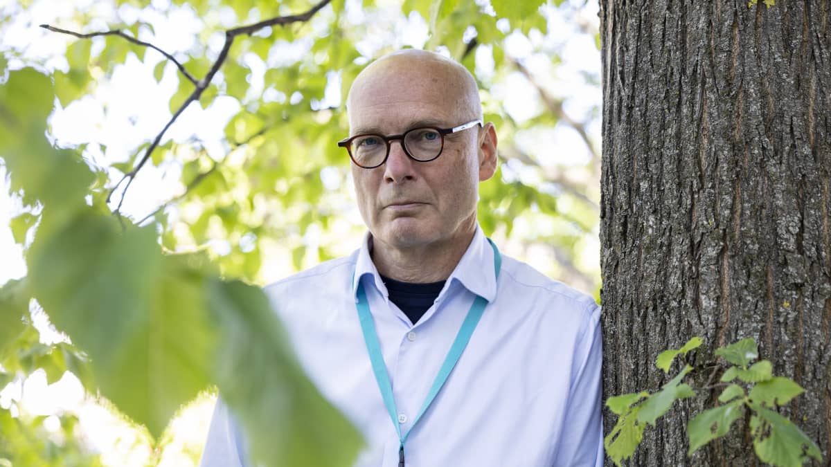 HUS:n psykiatrian ylilääkäri Risto Vataja nojaa puuhun.