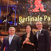 Näyttelijätär Baran Rasoulof, tuottajat Farzad Pak ja Kaveh Farnam poseeraavat Kultaisen karhun kanssa Berliinissä.