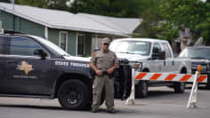 EN polis står utanför Robb Elementary School i Texas, där en 18-årig sköt minst 21 personer till döds. 
