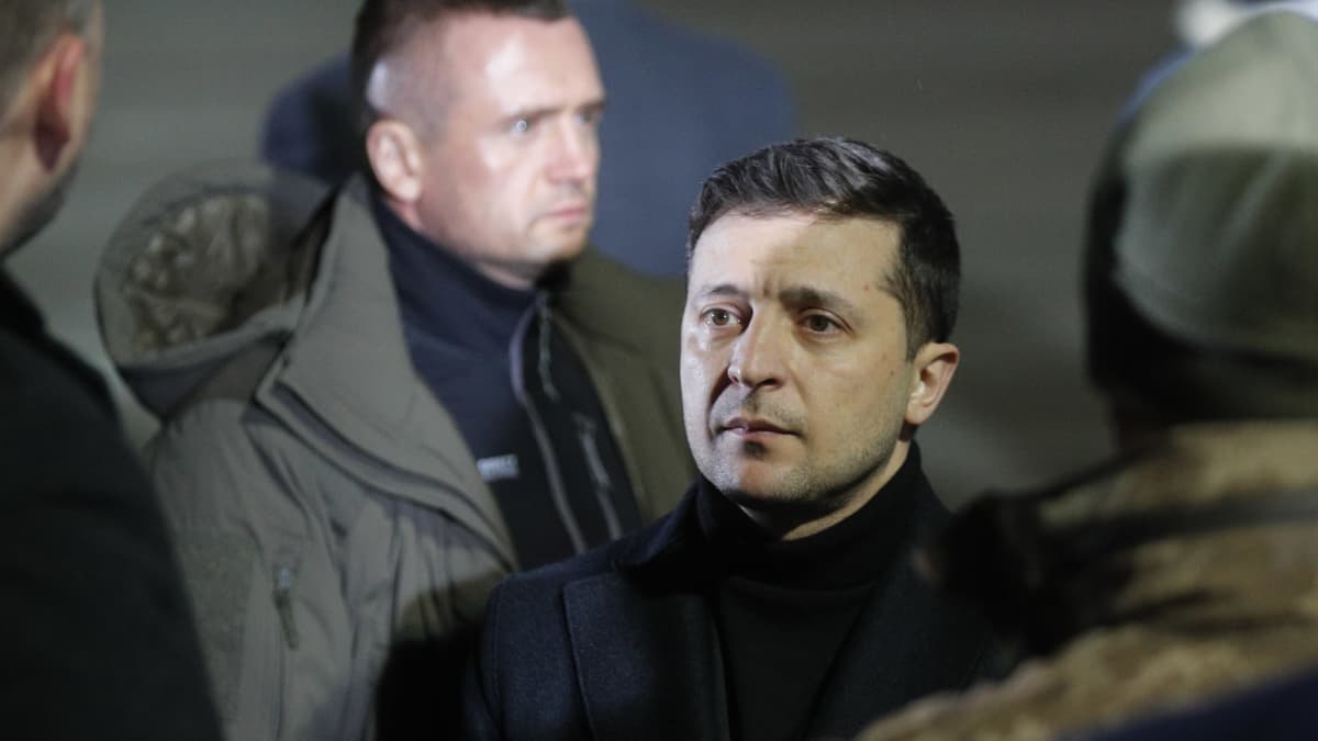 Ukrainan presidentti Zelenskyi miettiään näköisenä tummatakki päällä. 