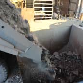 Kuorma-auto tuo kivilastin murskaamolle Kevitsan kaivoksella. Kivet tippuvat auton lavalta murskaamon kuiluun.
