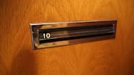 Postiluukku numero 10 puupintaisen oven keskellä.