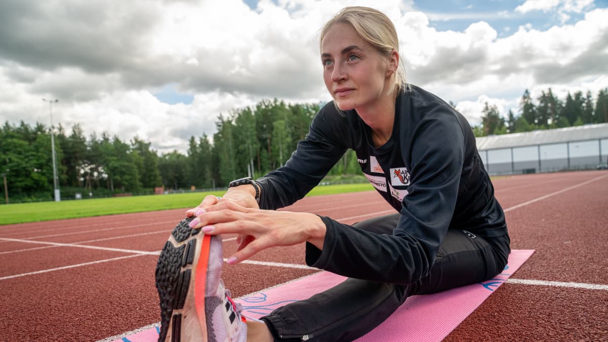 Juoksija Eveliina Määttänen venyttelee Keravan urheilukentällä 6.7.2022