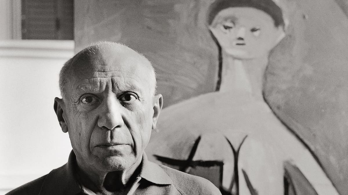 Pablo Picasso maalauksensa edessä.