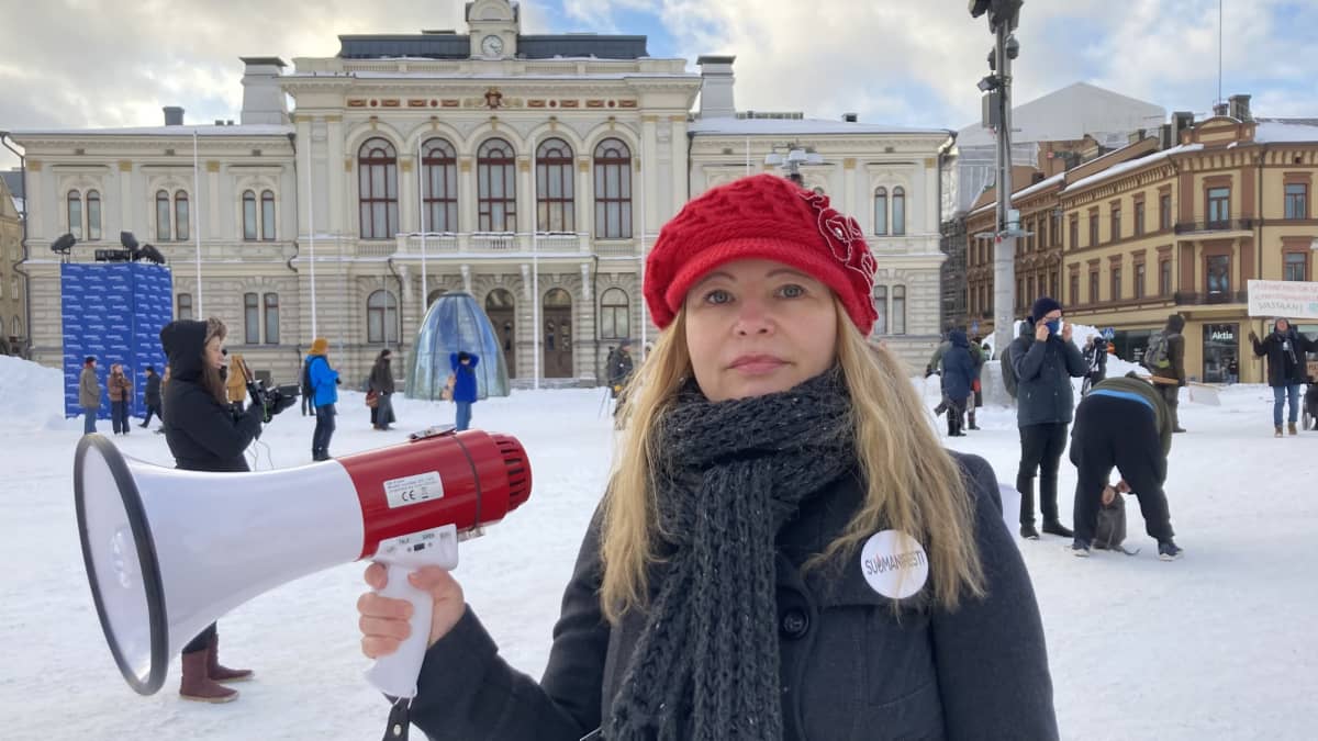 Emmi Liinalaakso pitelee megafonia Tampereen Keskustorilla. Takana näkyy paikalle kokoontuvia mielenosoittajia.
