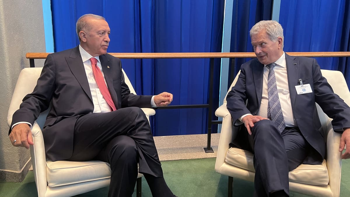 Recep Tayyip Erdogan och Sauli Niinistö sitter bredvid varandra på två fåtöljer. De tittar på varandra och talar.