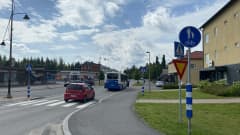 Kuhmoisten keskustan keskusraitti. Tampereen liikenteen Nysse on pysähtyneenä ottamaan ja sen perässä on punainen pikkuauto