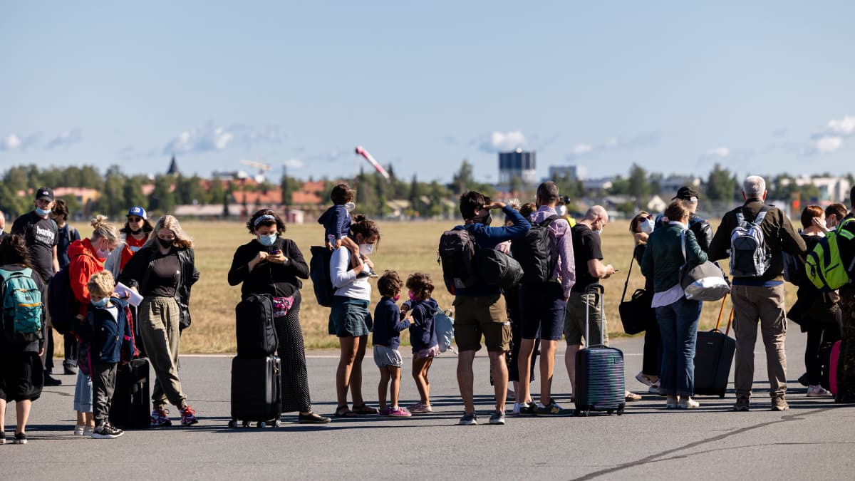 Turisteja odottamassa laukkujaan Lappeenrannan lentoasemalla.