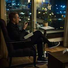 President Alexander Stubb sits holding a phone.