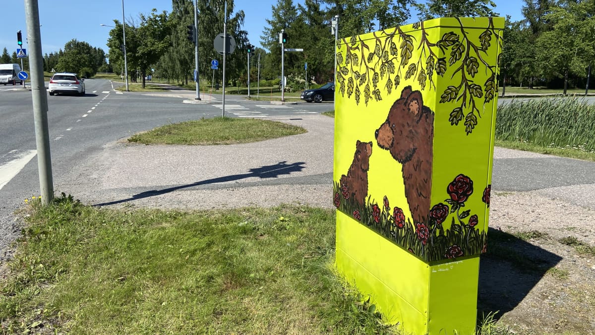 Karhu ja karhunpentu maalattuna keltaisella pohjalla jakokaappiin Riihimäellä Kirjauksentien varrella.