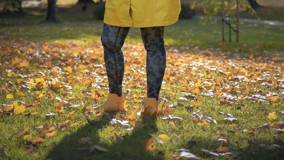 Sofia Heinonen seisoo puistossa keltaisessa takissa, kädet lantiollaan, katsoo vasemmalle.