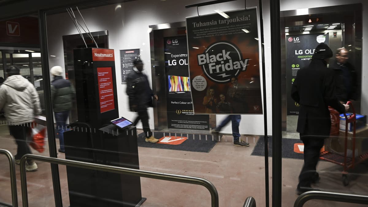 Ihmisiä ostoksilla verkkokaupassa, black friday julisteita ikkunoissa