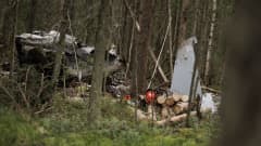 Osa pudonneen Hawk-koneen runkoa ja sen peräsintä metsässä puitten seassa.