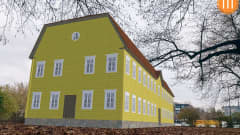 3D-mallinnoksella tehty keltainen puutalo Turun linnapuiston alueelle.