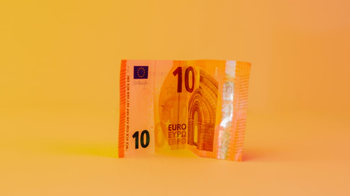 Kymmenen euron seteli oranssilla taustalla.