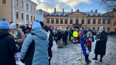 Ihmisiä jonottamassa opiskelijatapahtuma Pikkulaskiaisen lipunmyyntipisteelle Turun suurtorilla loskaisessa säässä.