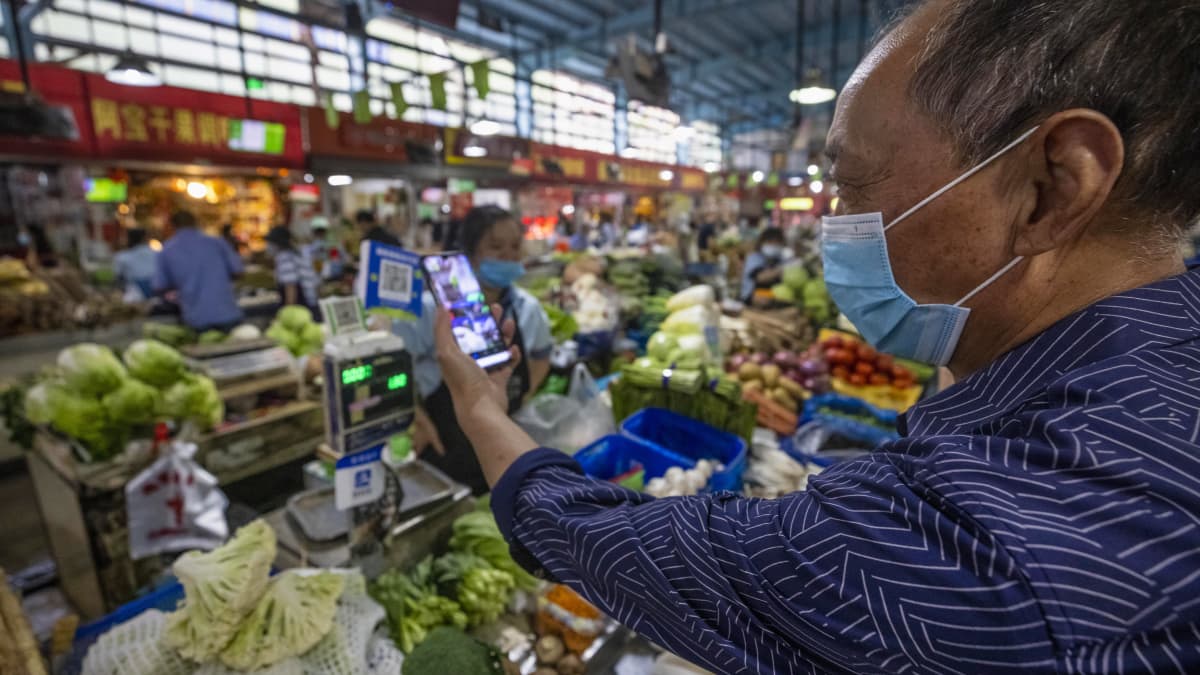 Kiinan Hangzhoussa tuoretuotteita myyvällä torilla asiakas skannasi QR-maksukoodia ostosten tekemistä varten 27. syyskuuta 2020.
