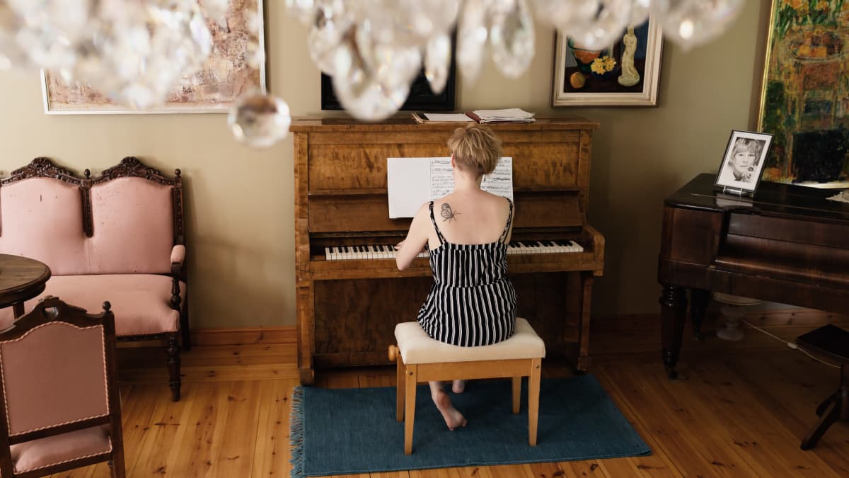 Kirjailija Marianna Kurtto soittaa pianoa Eeva Joenpellon kirjailijakoti-residenssissä..