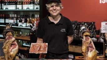 Nainen esittelee ilmakuivattua kinkkua barcelonalaisessa kinkkukaupassa.