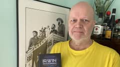Irwin Goodman - Kansan taiteilija -kirjan kirjoittaja Kimmo Miettinen Irwin -tarinoita sisältävä kirja kädessään.