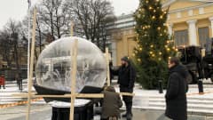 Turun kauppatorilla viimeistellään lumisadepalloa, joka on taideinstallaatio.